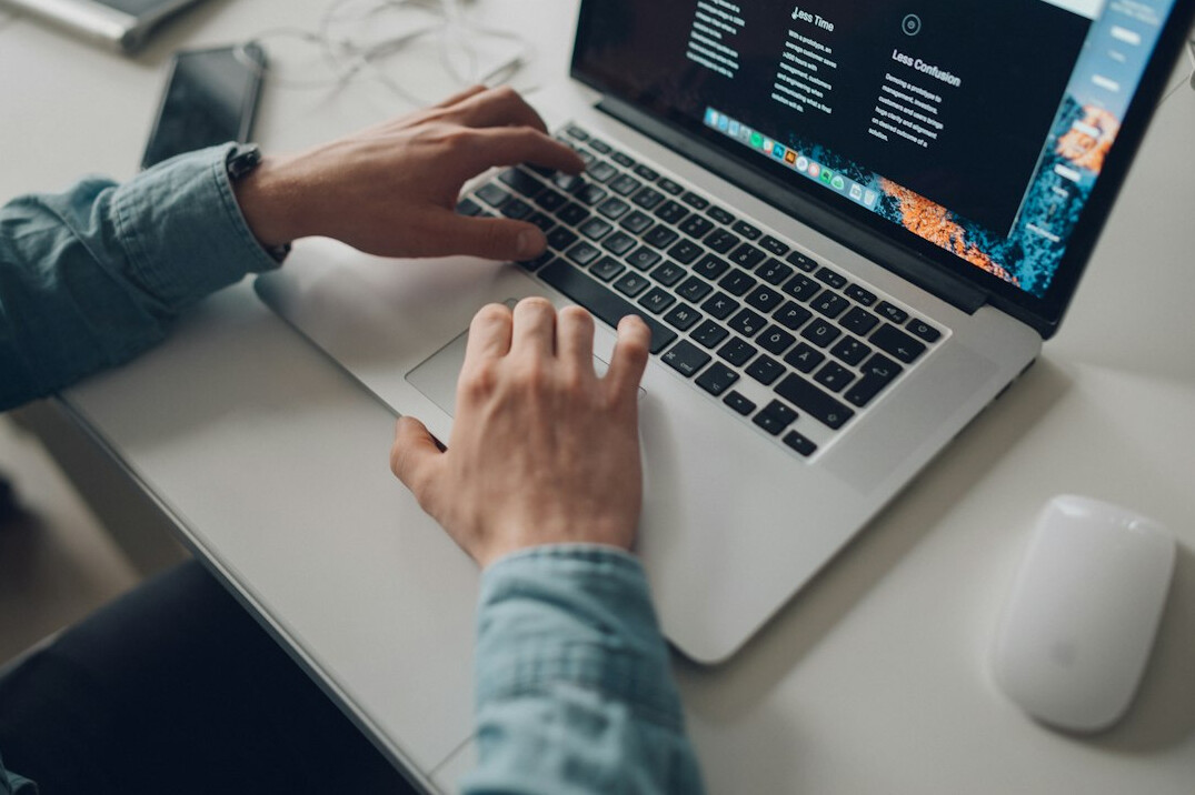 person coding on laptop