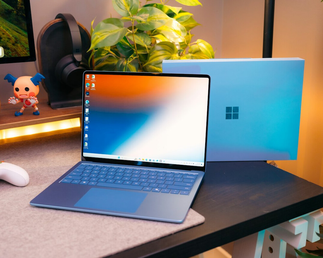 Open notebook with pen next to a laptop on a desk