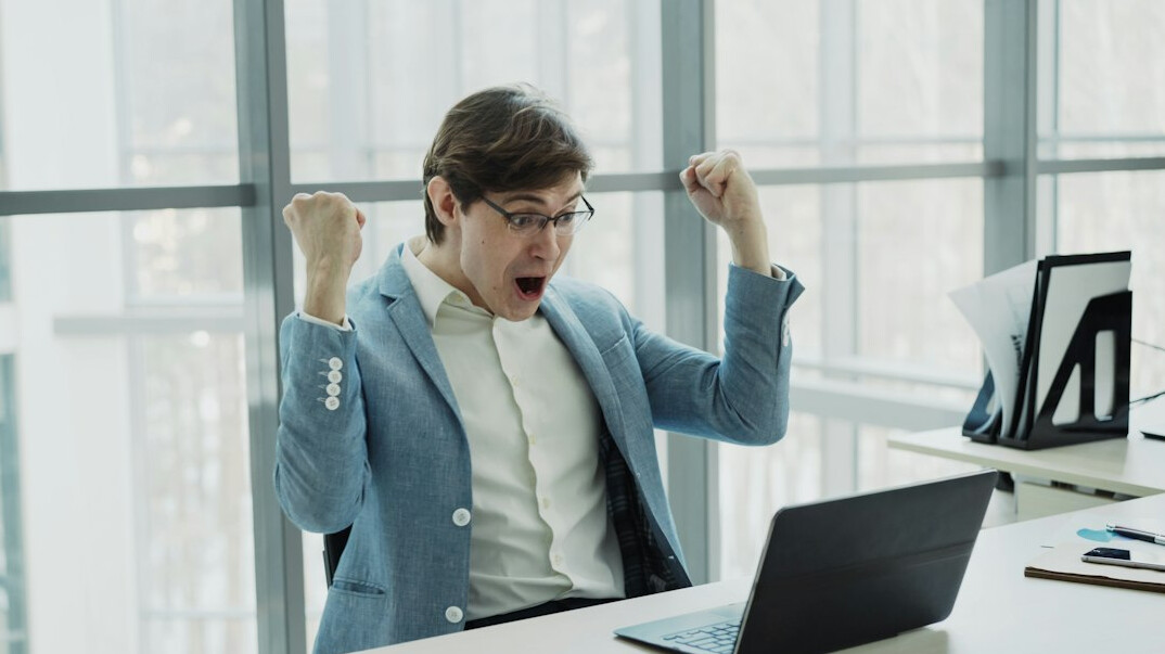 person celebrating success at computer